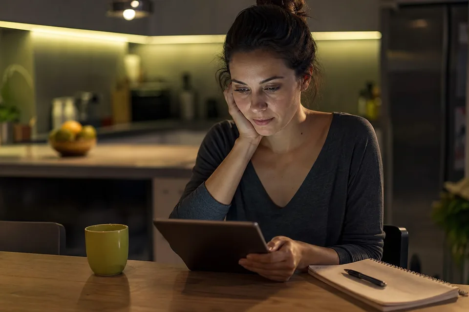 Creator reviewing her monthly payout on a tablet at a kitchen table